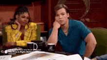 a man and a woman are sitting at a table looking at each other .