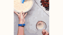 a person is mixing batter in a bowl with a spatula .