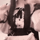 a girl is holding a pink purse and wearing a black and white dress .