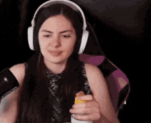 a woman wearing headphones is sitting in a purple chair holding a yellow object