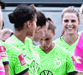 a group of female soccer players are standing next to each other .