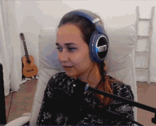 a woman wearing a pair of sennheiser headphones sitting in a chair