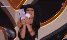 a woman blowing a kiss while holding a stack of 500 pesos bills