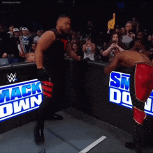 a man stands in front of a sign that says ' smack down ' on it