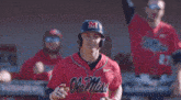 a baseball player wearing a red jersey with ole miss written on it