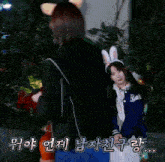 a woman in a bunny costume is standing next to another woman in a jacket