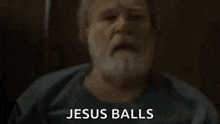 a man with a beard is holding his head in pain while sitting in a chair .