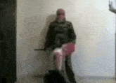 a man in a mask is standing next to a woman in a pink skirt holding a sword .