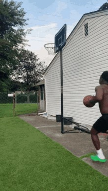 a man is playing basketball in front of a house