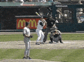 a baseball player getting ready to bat in front of a mcdonald 's sign