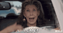 a woman is driving a car and says i can t