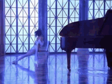 a woman is sitting on a chair in front of a grand piano