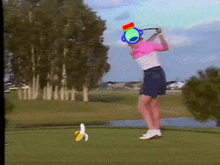 a woman swinging a golf club on a golf course with a banana in the foreground