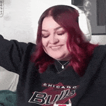 a woman with red hair is wearing headphones and a chicago bulls sweatshirt