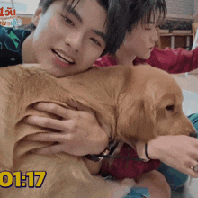 a man is holding a dog with the time 1:17 on the bottom