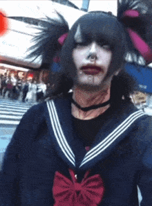 a person with blood on their face wearing a sailor suit