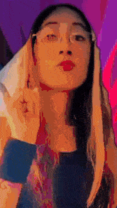 a woman wearing glasses and red lipstick is making a face .