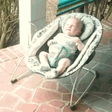 a baby is sitting in a bouncer on a patio