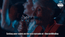 a woman holding a pair of binoculars with the words setting your sights on the next episode of #doctor whoday below her