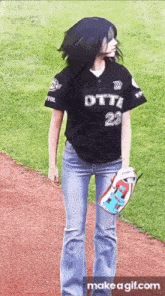 a woman in a baseball uniform is standing on a baseball field .