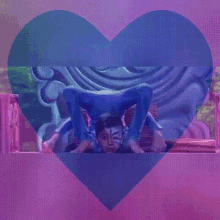 a boy with face paint on his face is doing a handstand in a heart shaped frame .