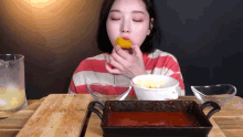 a woman is eating a piece of food next to a bowl of food