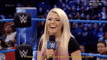 a woman in a wrestling ring with a microphone laughing