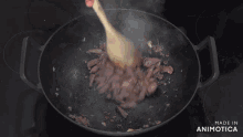 a man is stirring food in a wok and the words made in animatica are on the stove