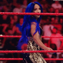 a woman with blue hair is standing in a boxing ring