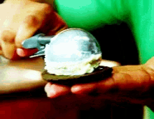 a person is holding an ice cream scoop in their hand
