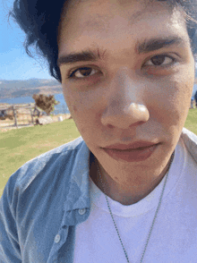 a close up of a person 's face with a blue shirt and white shirt
