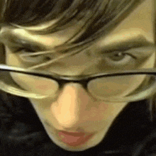 a close up of a person wearing glasses and a black jacket