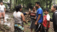 a group of people are standing in a muddy area with the word happily on the bottom right