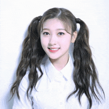 a girl with pigtails and a white shirt smiles