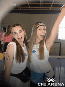 two girls with tk written on their arms pose for a picture