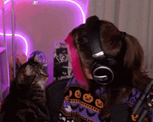 a woman wearing headphones and a sweater with pumpkins on it