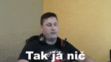 a man wearing headphones and a black converse shirt says takja nic
