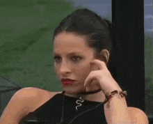 a woman wearing a choker and a necklace with a snake on it .