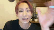 a man with red hair is waving his hand in front of a sign that says ' ts ' on it