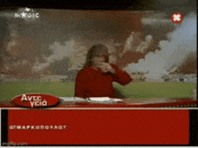 a woman in a red sweater is sitting at a red desk in front of a red sign that says avec ycia