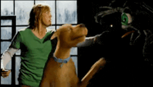 a man and a dog are standing next to each other in a room .
