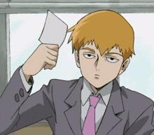a man in a suit and tie is holding up a piece of paper