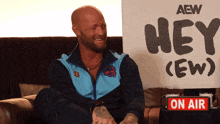 a man sits in front of a sign that says hey