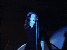 a woman singing into a microphone and holding a tambourine