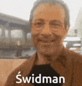 a man wearing glasses and a brown jacket with the name swidman on the bottom right