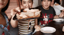 a woman holding a tray of food with a man in a t-shirt that says ' i love you '
