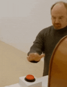 a man is pressing a red button on a box