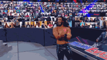 a wrestler is standing in front of a huge crowd at a main event