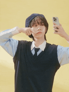 a person wearing a blue hat and vest is taking a selfie with their phone