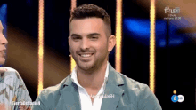 a man is smiling in front of a television screen that says talent